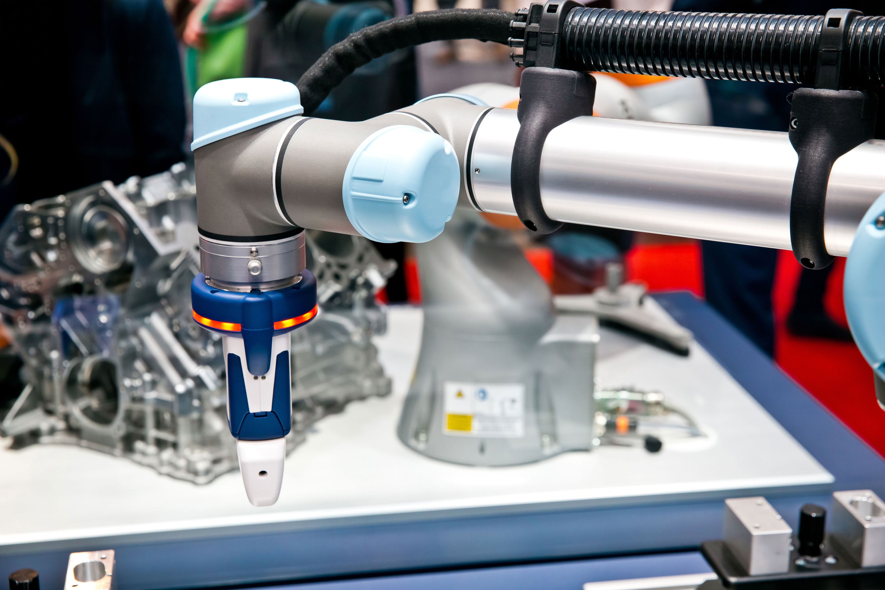 A silver and blue Universal robot arm with a custom gripper.