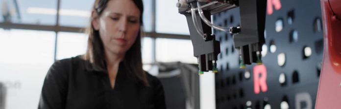 A woman programming an industrial robot.