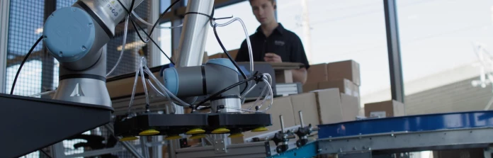 An engineer trains a Universal Robots cobot on a palletizing task.